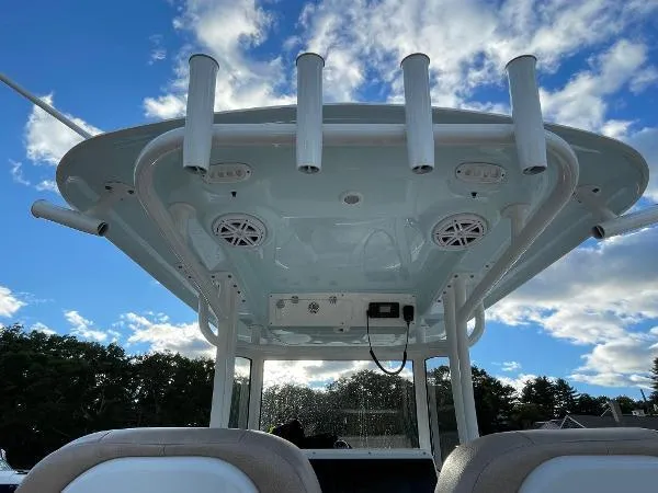 Slide: The Image of 2019 Sportsman 282 boat top view with rod holders and speakers against a blue sky. - 11