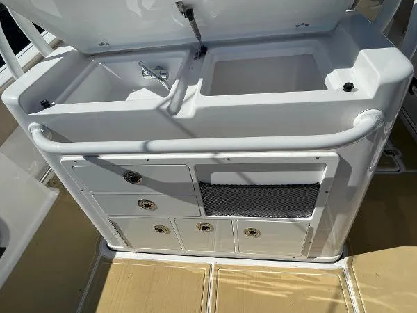 Slide: The Image of 2019 Sportsman 282 boat sink and storage compartments on deck. - 13