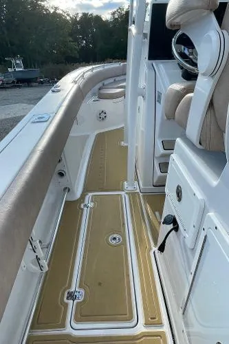 Slide: The Image of 2019 Sportsman 282 boat interior with tan deck and cushioned seating. - 15