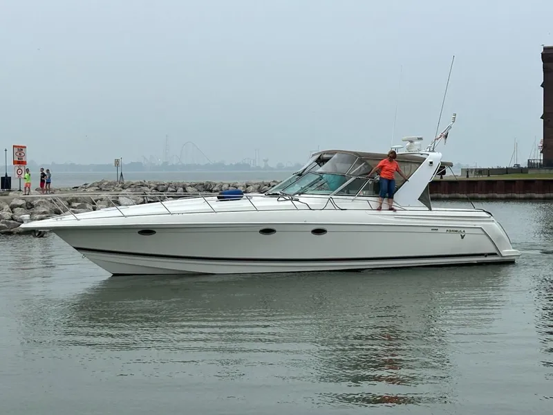 Slide: The Image of 2000 Formula 41 PC yacht cruising near rocky shoreline on a cloudy day. - 0