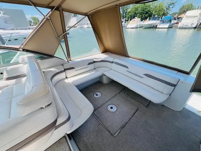 Slide: The Image of 2000 Formula 41 PC boat interior with white seating and canopy, docked at marina. - 6