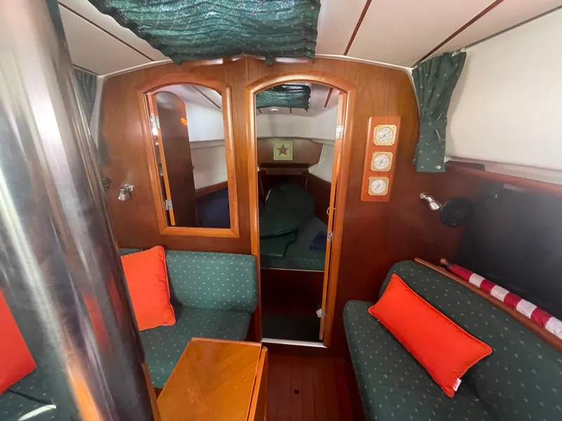 Slide: The Image of Interior of 1999 Beneteau Oceanis 36 CC sailboat with cozy seating and wooden finishes. - 12
