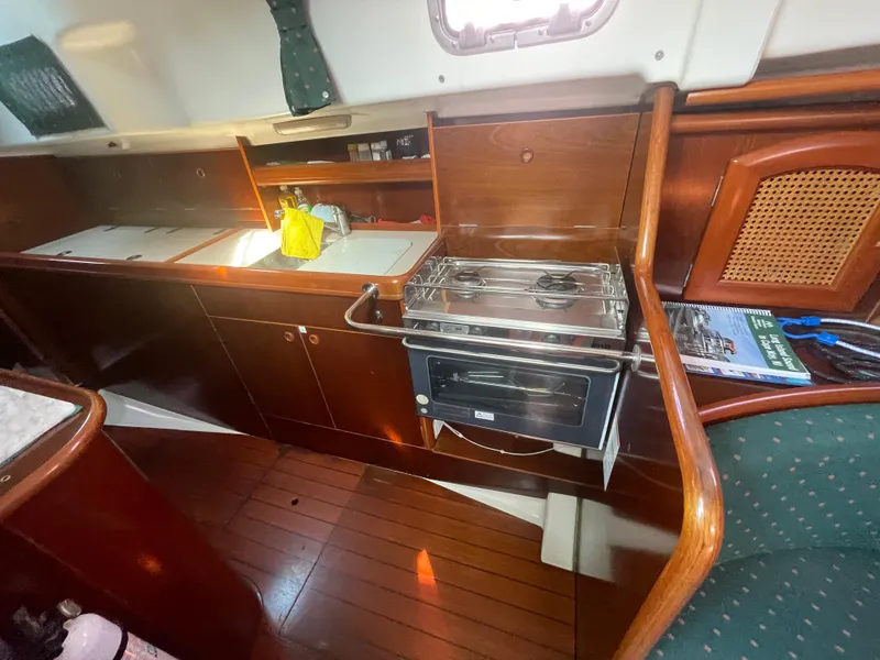Slide: The Image of Interior of 1999 Beneteau Oceanis 36 CC yacht, featuring a compact kitchen area. - 16