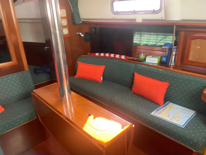 Slide: The Image of Interior of 1999 Beneteau Oceanis 36 CC sailboat with green seating and orange cushions. - 20