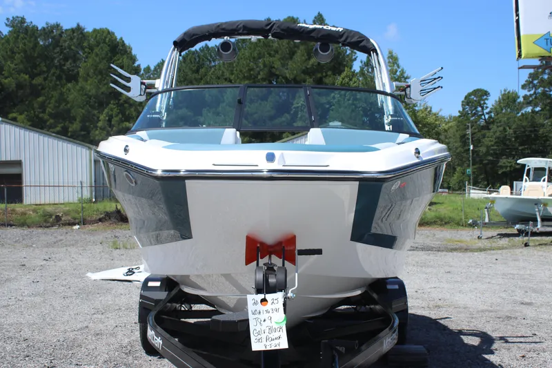 Slide: The Image of 2025 MasterCraft NXT21 boat on trailer, front view, outdoors, sunny day. - 10