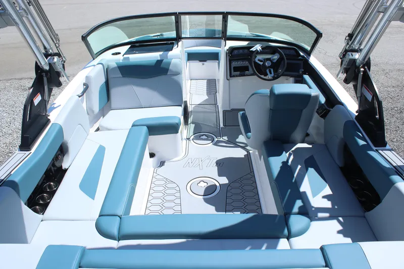 Slide: The Image of 2025 MasterCraft NXT21 boat interior with blue and white seating, modern dashboard, and open layout. - 14
