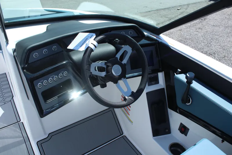 Slide: The Image of 2025 MasterCraft NXT21 boat cockpit with modern steering wheel and control panel. - 16