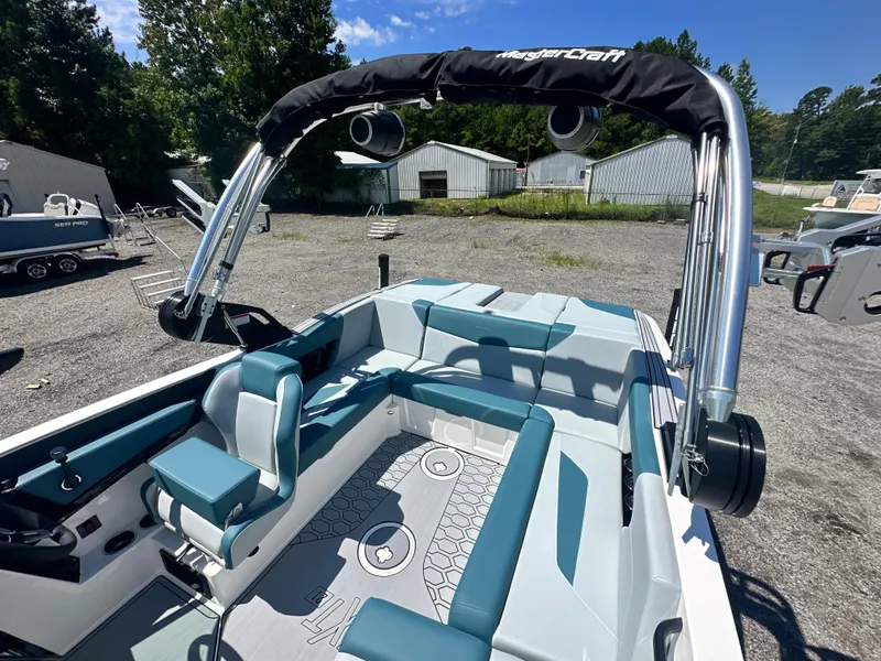 Slide: The Image of 2025 MasterCraft NXT21 boat interior with blue and gray seating, outdoor setting. - 4
