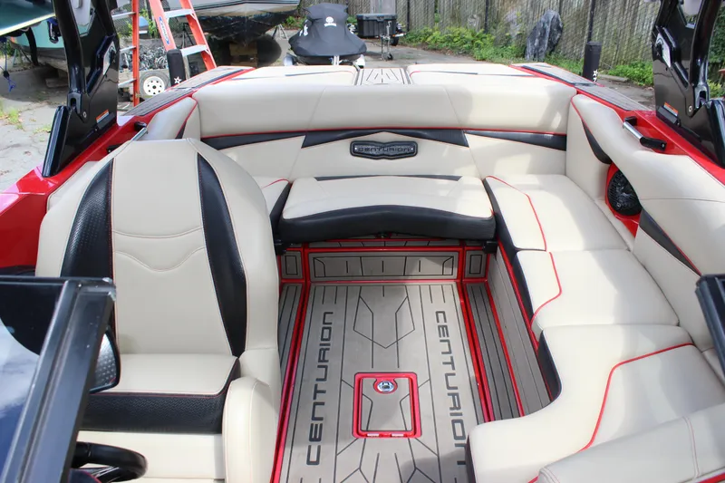 Slide: The Image of 2021 Centurion Fi21 boat interior with beige and black seating, red accents, and branded flooring. - 29