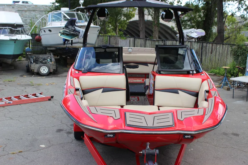 Slide: The Image of Red 2021 Centurion Fi21 boat with beige interior, parked outdoors. - 48