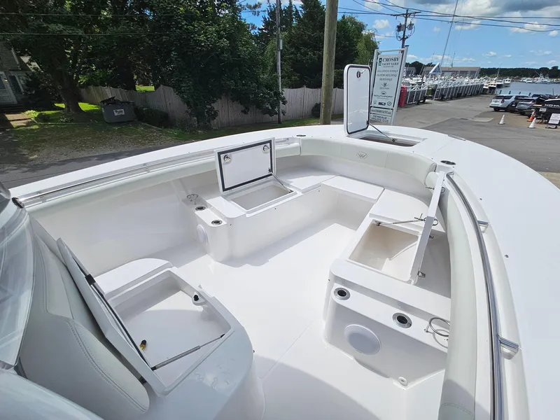 Slide: The Image of 2025 Southport 30 FE boat interior with open storage compartments, white seating, and clear sky. - 28