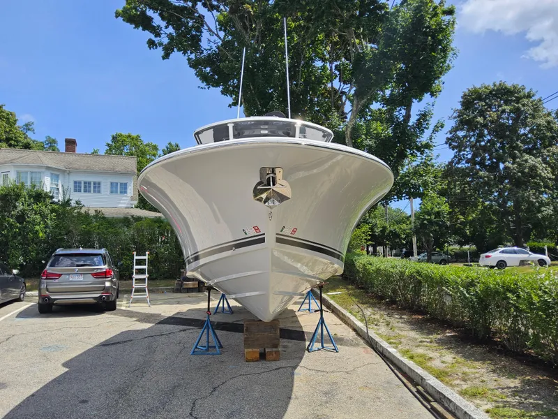 Slide: The Image of 2025 Southport 30 FE boat on stands in a driveway, surrounded by trees and cars. - 5