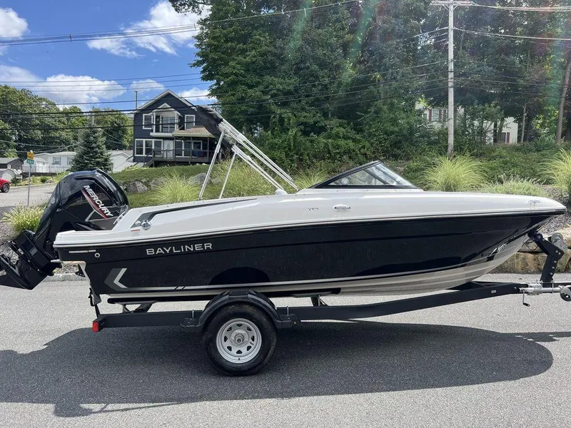 Slide: The Image of 2025 Bayliner VR4 Bowrider Outboard on trailer, parked outdoors, side view. - 2