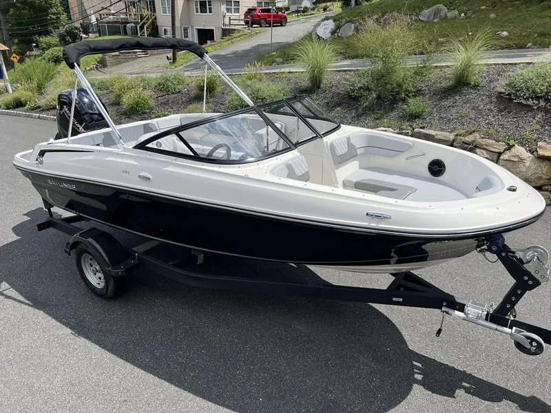 Slide: The Image of 2025 Bayliner VR4 Bowrider Outboard on trailer, parked on a residential street. - 5
