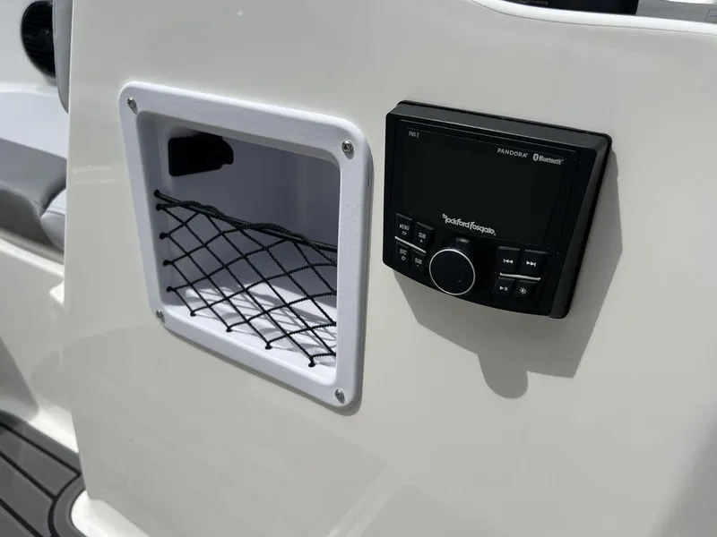 Slide: The Image of 2025 Bayliner VR4 Bowrider dashboard with storage compartment and Rockford Fosgate audio system. - 7