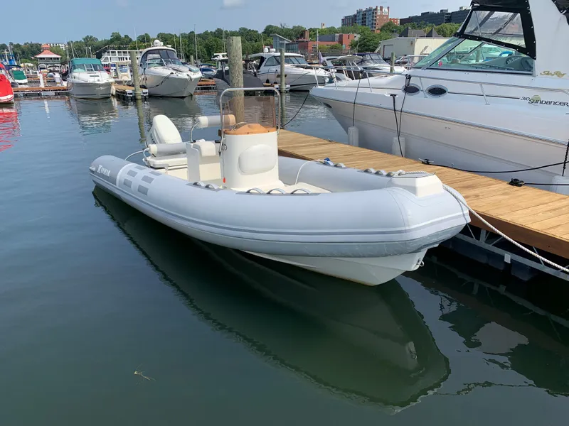 Slide: The Image of 2019 Inmar 635 inflatable boat docked at a marina with other vessels. - 2