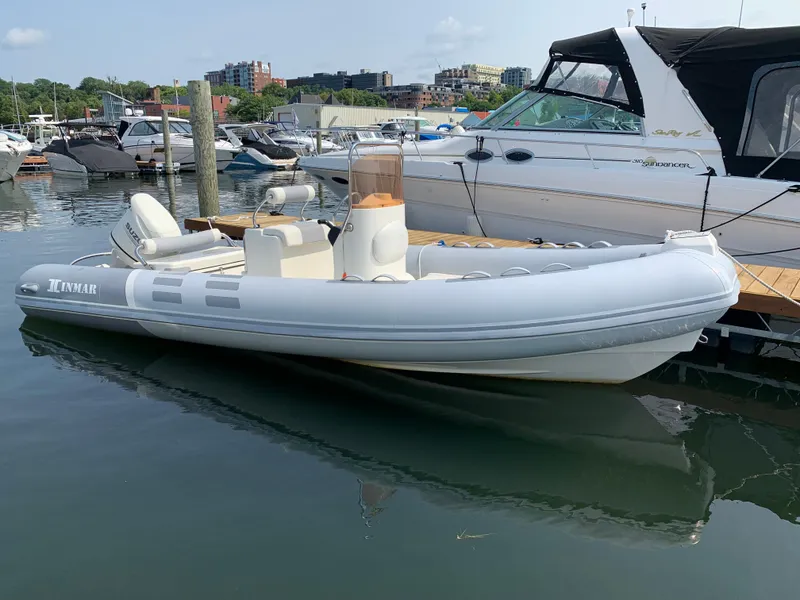 Slide: The Image of 2019 Inmar 635 inflatable boat docked in a marina, surrounded by other vessels. - 3