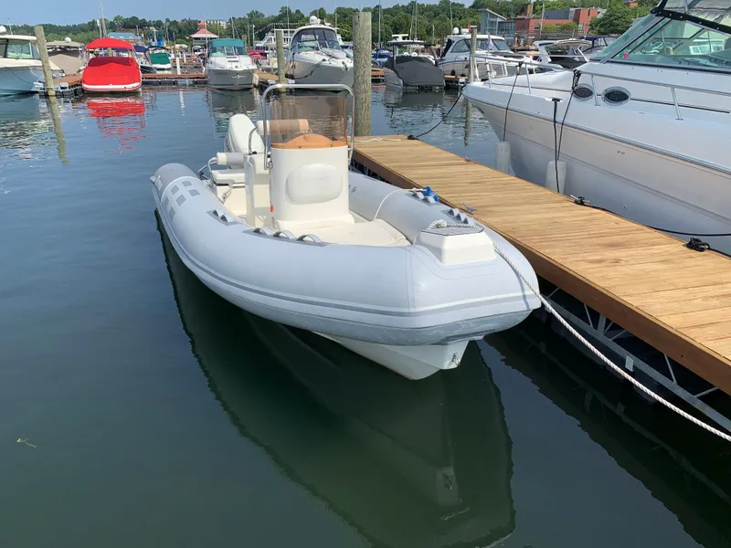 Slide: The Image of 2019 Inmar 635 inflatable boat docked at a marina, surrounded by other vessels. - 4