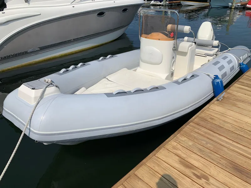 Slide: The Image of 2019 Inmar 635 inflatable boat docked at marina, featuring sleek design and spacious seating. - 5