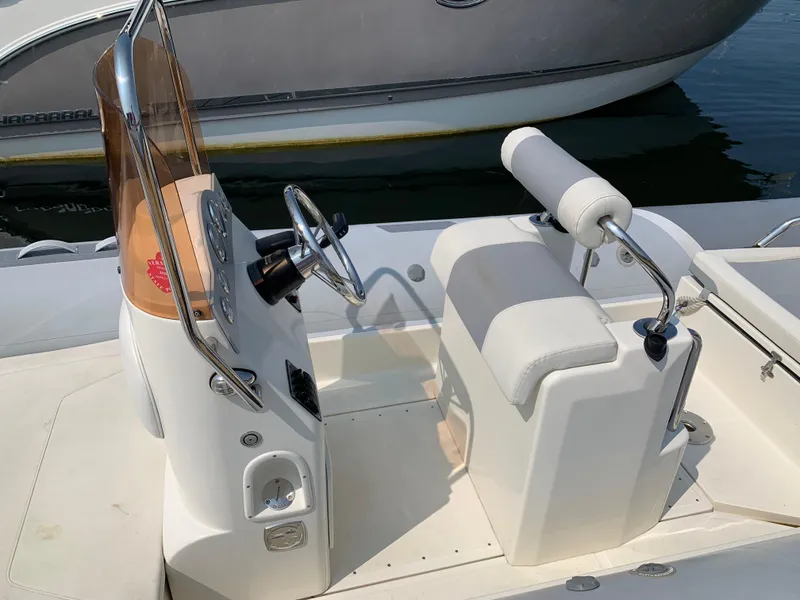 Slide: The Image of 2019 Inmar 635 boat interior with steering console and cushioned seating. - 8