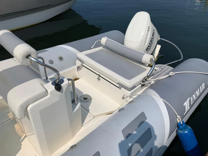 Slide: The Image of 2019 Inmar 635 inflatable boat with seating and motor, docked on calm water. - 9