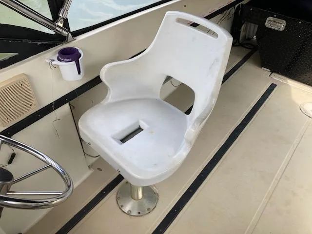 Slide: The Image of Captain's chair on 1982 Albemarle 24 boat, featuring a white seat and steering wheel. - 3