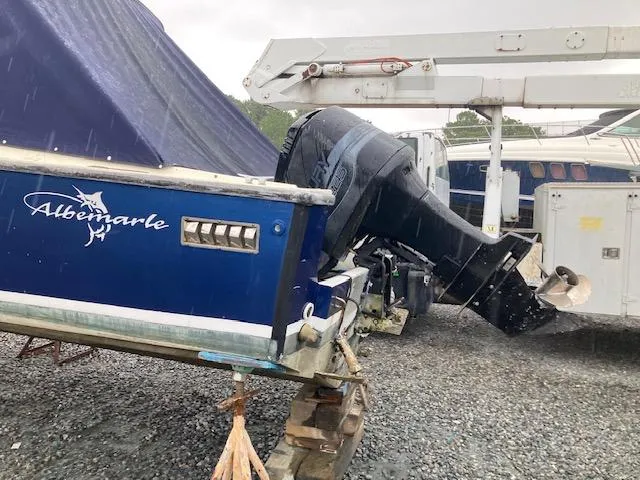 Slide: The Image of 1982 Albemarle 24 boat with outboard motor on a trailer in a rainy setting. - 4
