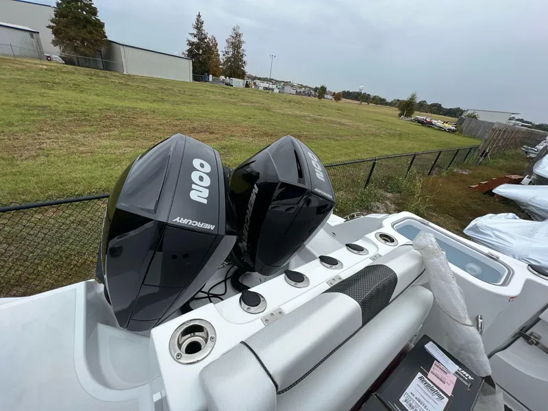 Slide: The Image of 2023 Wellcraft 262 Fisherman boat with dual Mercury outboard engines, parked outdoors. - 11