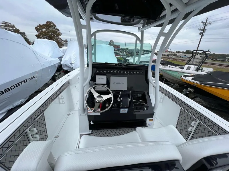 Slide: The Image of 2023 Wellcraft 262 Fisherman boat interior with steering wheel and Garmin navigation system. - 13