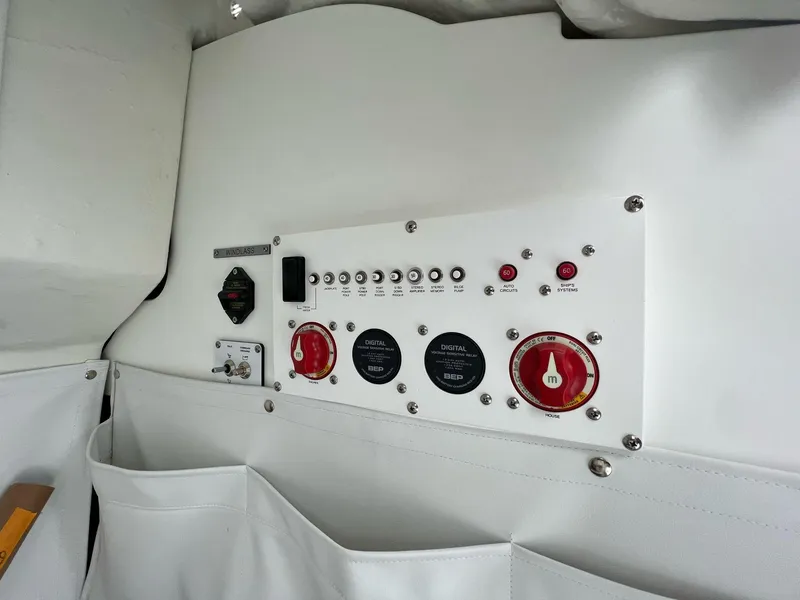 Slide: The Image of 2023 Wellcraft 262 Fisherman control panel with switches and storage pockets. - 28