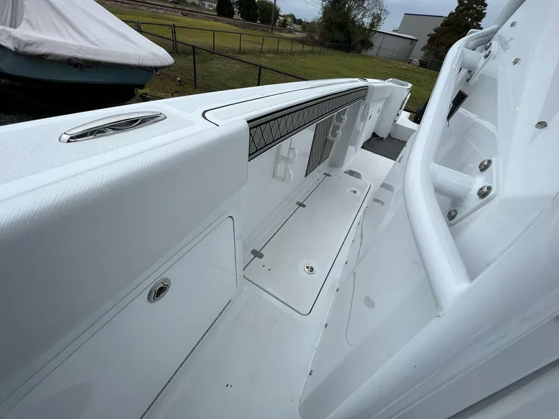 Slide: The Image of 2023 Wellcraft 262 Fisherman boat interior, featuring sleek white design and storage compartments. - 34