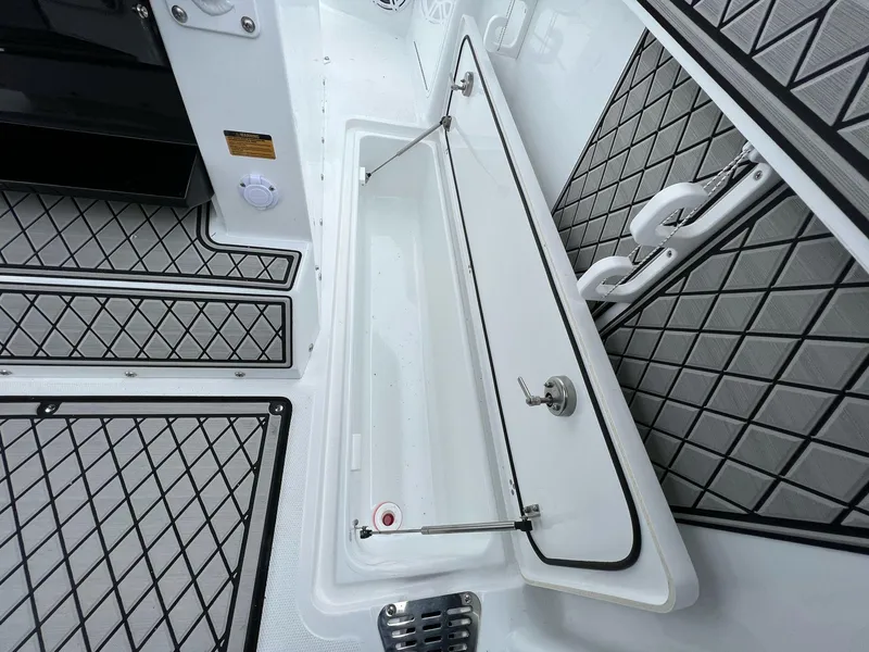 Slide: The Image of 2023 Wellcraft 262 Fisherman boat interior with open storage compartment and diamond-patterned flooring. - 36