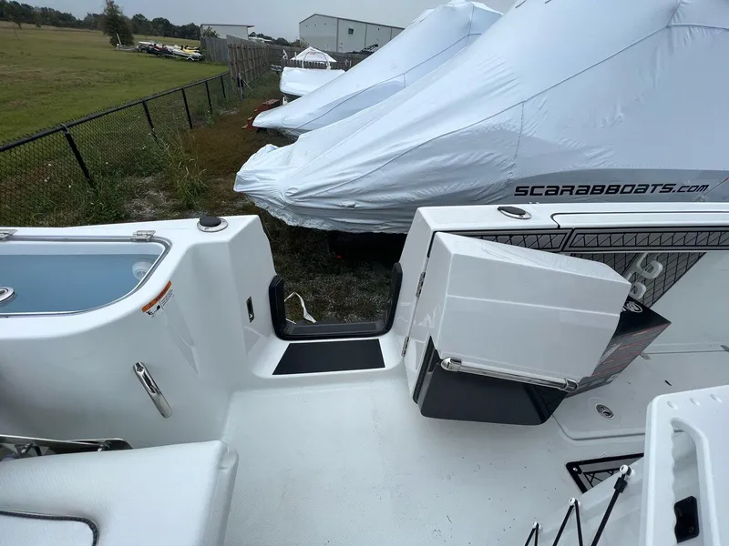 Slide: The Image of 2023 Wellcraft 262 Fisherman boat interior with storage and covered boats in background. - 44