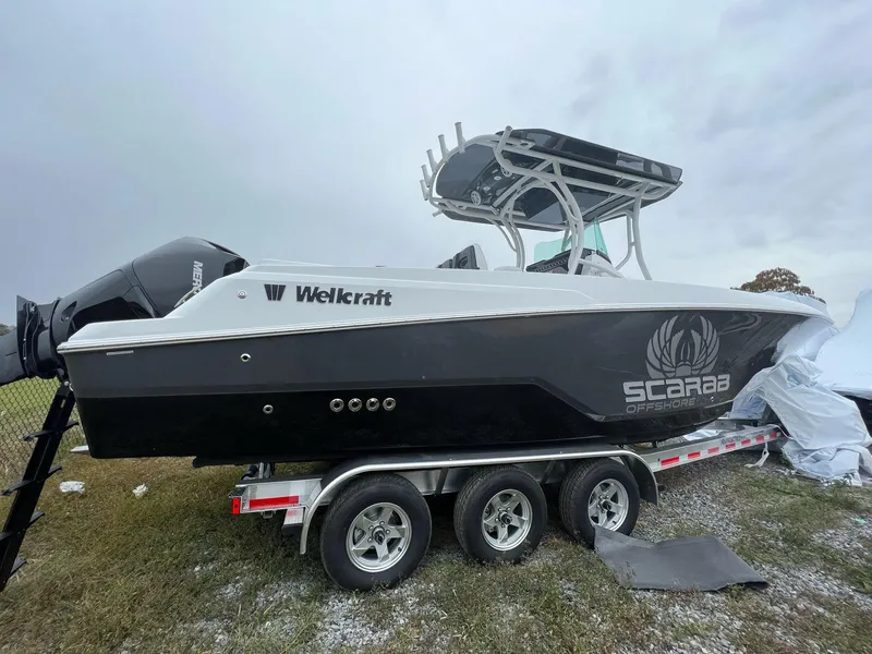 Slide: The Image of 2023 Wellcraft 262 Fisherman boat on trailer, black and white design, Scarab Offshore logo. - 47