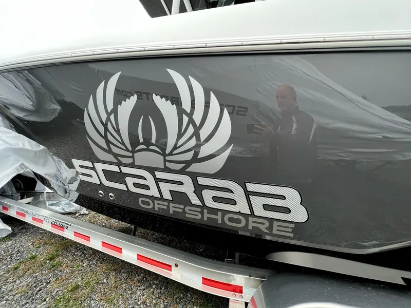 Slide: The Image of 2023 Wellcraft 262 Fisherman boat with Scarab Offshore logo on trailer. - 7