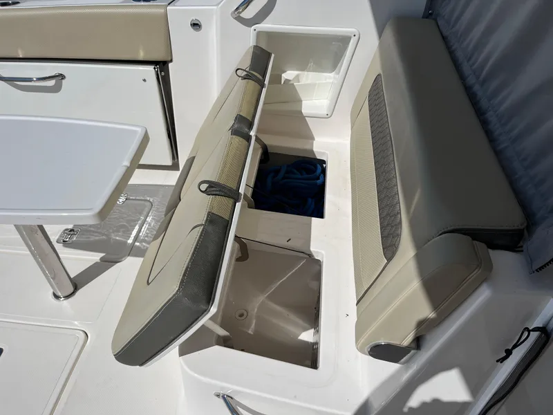 Slide: The Image of 2018 Pursuit DC 365 Dual Console boat interior with open storage compartments. - 15