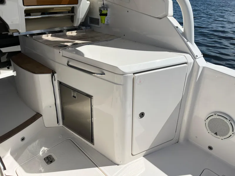 Slide: The Image of 2018 Pursuit DC 365 Dual Console boat interior with storage and seating. - 16