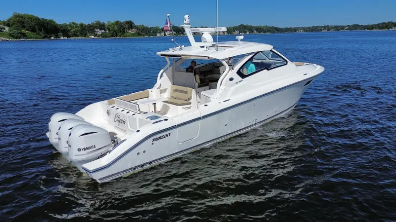 Slide: The Image of 2018 Pursuit DC 365 Dual Console boat on a sunny lake. - 2