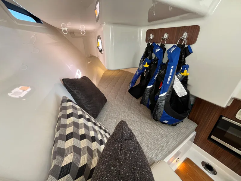 Slide: The Image of 2018 Pursuit DC 365 Dual Console cabin with cushions and life jackets. - 31