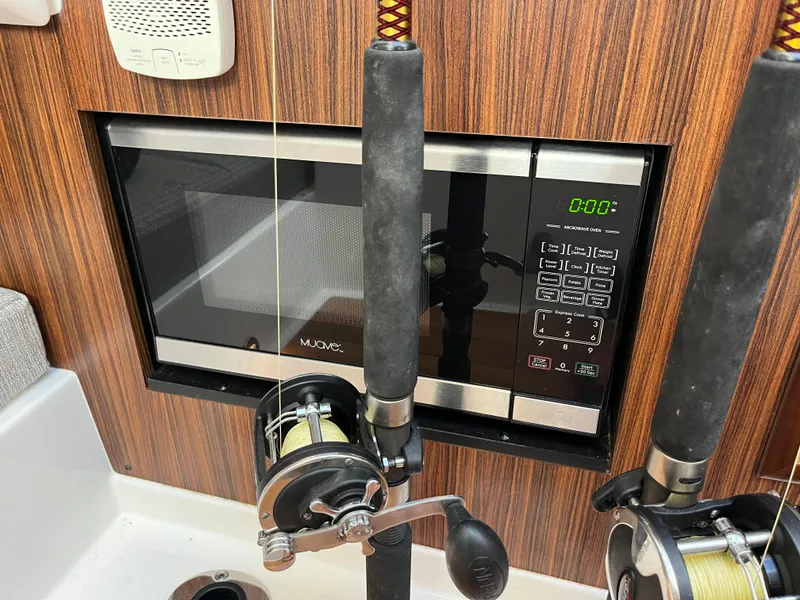 Slide: The Image of Fishing rods and microwave on 2018 Pursuit DC 365 Dual Console boat. - 32