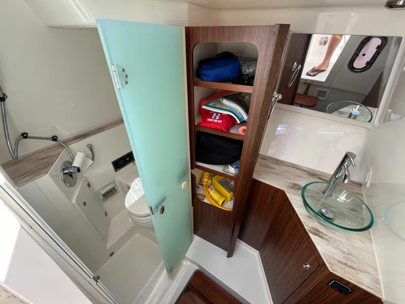 Slide: The Image of 2018 Pursuit DC 365 Dual Console boat bathroom with storage shelves and modern fixtures. - 40