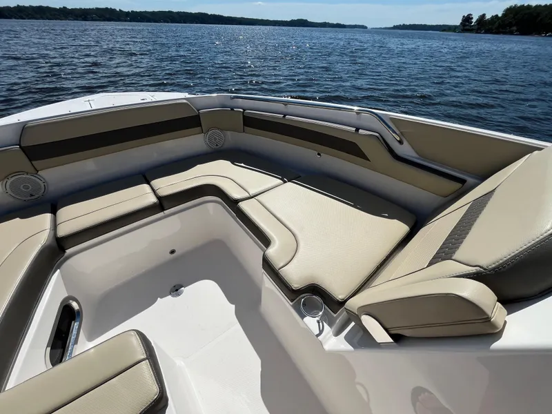 Slide: The Image of 2018 Pursuit DC 365 Dual Console boat interior with beige seating on a lake. - 43