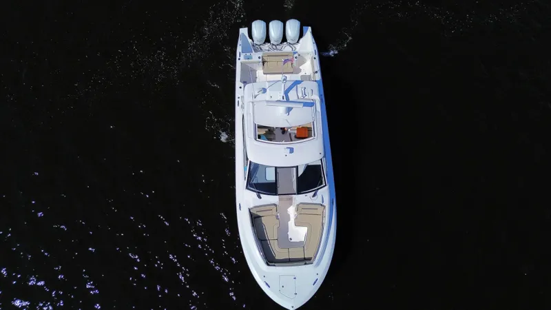 Slide: The Image of Aerial view of 2018 Pursuit DC 365 Dual Console boat on dark water. - 8