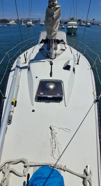 Slide: The Image of 1987 C&C 38 MKIII sailboat deck with clear blue water and moored boats. - 18