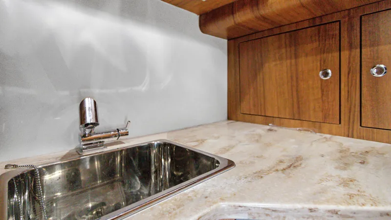 Slide: The Image of Luxury yacht kitchen sink with marble countertop and wooden cabinets, Invincible 42 Center Console Cabin 2021. - 25