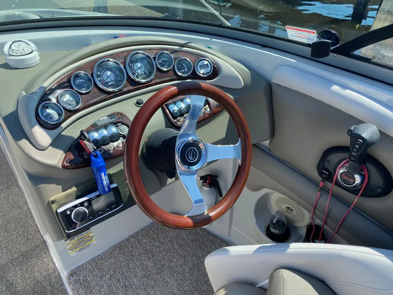 Slide: The Image of 2015 Crownline Eclipse E2 boat dashboard with wood-accented steering wheel and instrument panel. - 7