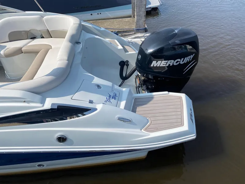 Slide: The Image of 2015 Crownline Eclipse E2 boat with Mercury outboard motor, docked on calm water. - 13