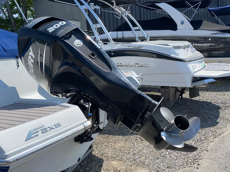 Slide: The Image of 2015 Crownline Eclipse E2 boat with powerful outboard motor, parked on gravel. - 14