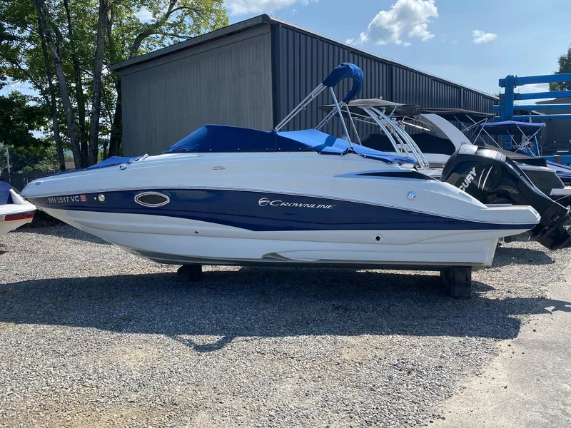 Slide: The Image of 2015 Crownline Eclipse E2 boat with blue canopy, parked on gravel. - 3
