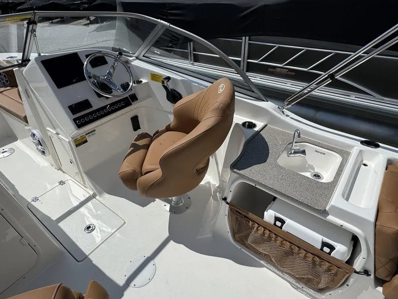 Slide: The Image of 2025 Key West 239 DFS boat interior with helm, seat, and sink. - 12